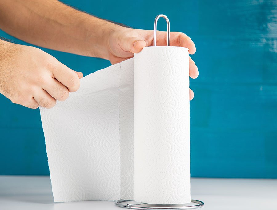 Una persona arranca una servilleta del rollo de papel de cocina.