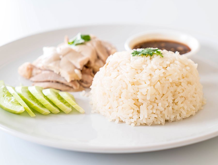 Plato con trocitos de pollo a la plancha, pepino, arroz blanco y salsa de soja.