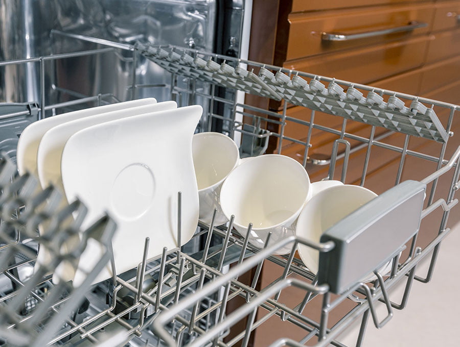 La bandeja del lavaplatos está fuera y lista para recoger los platos y vasos.