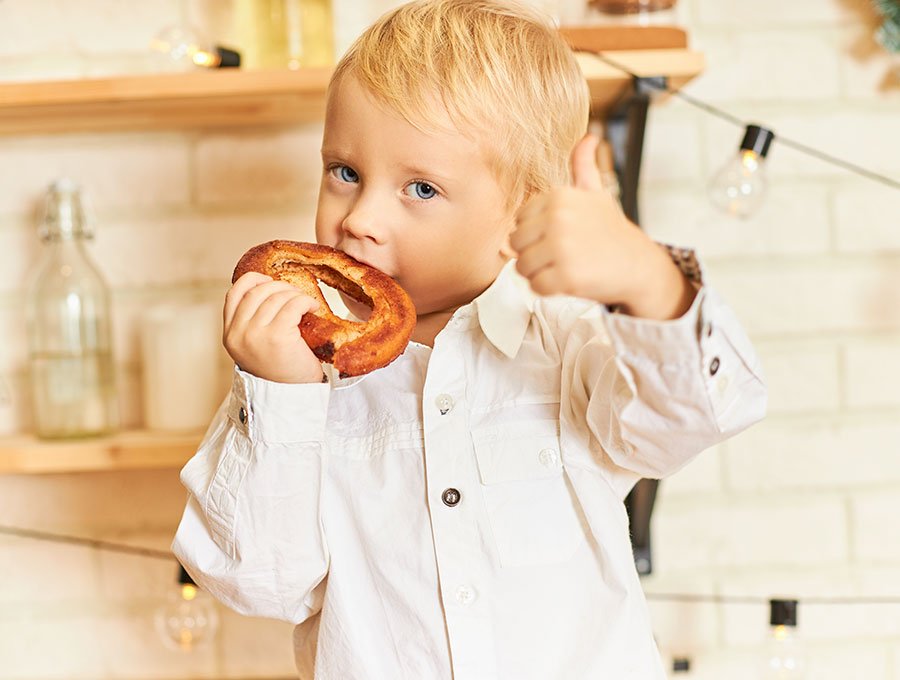 Niño pequeño disfrutando de un bagel matutino.